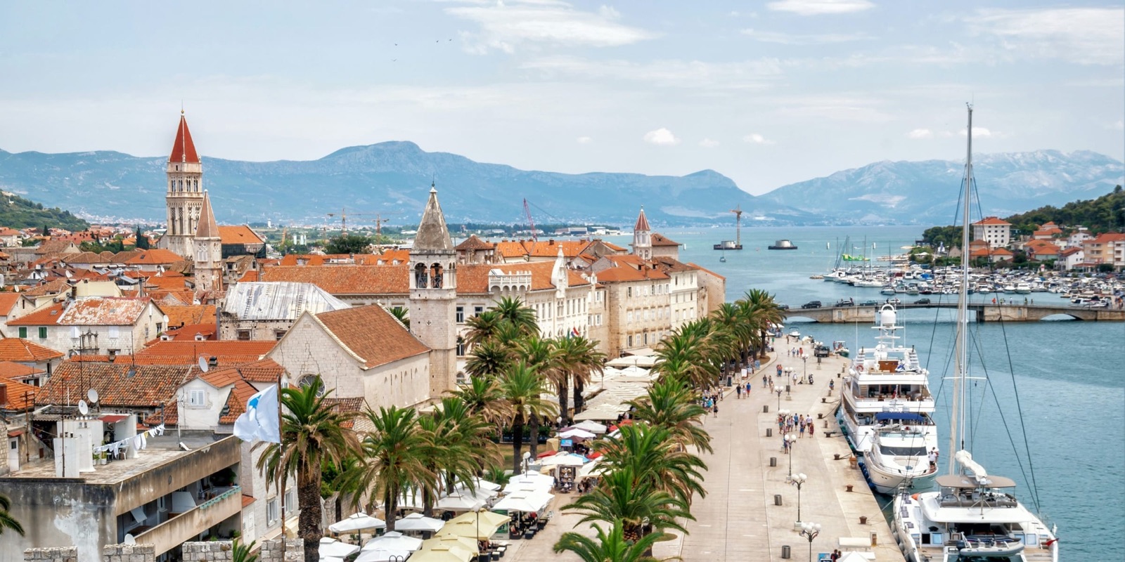 Trogir UNESCO waterfront with stone facades and harbor boats on the Adriatic, Croatia